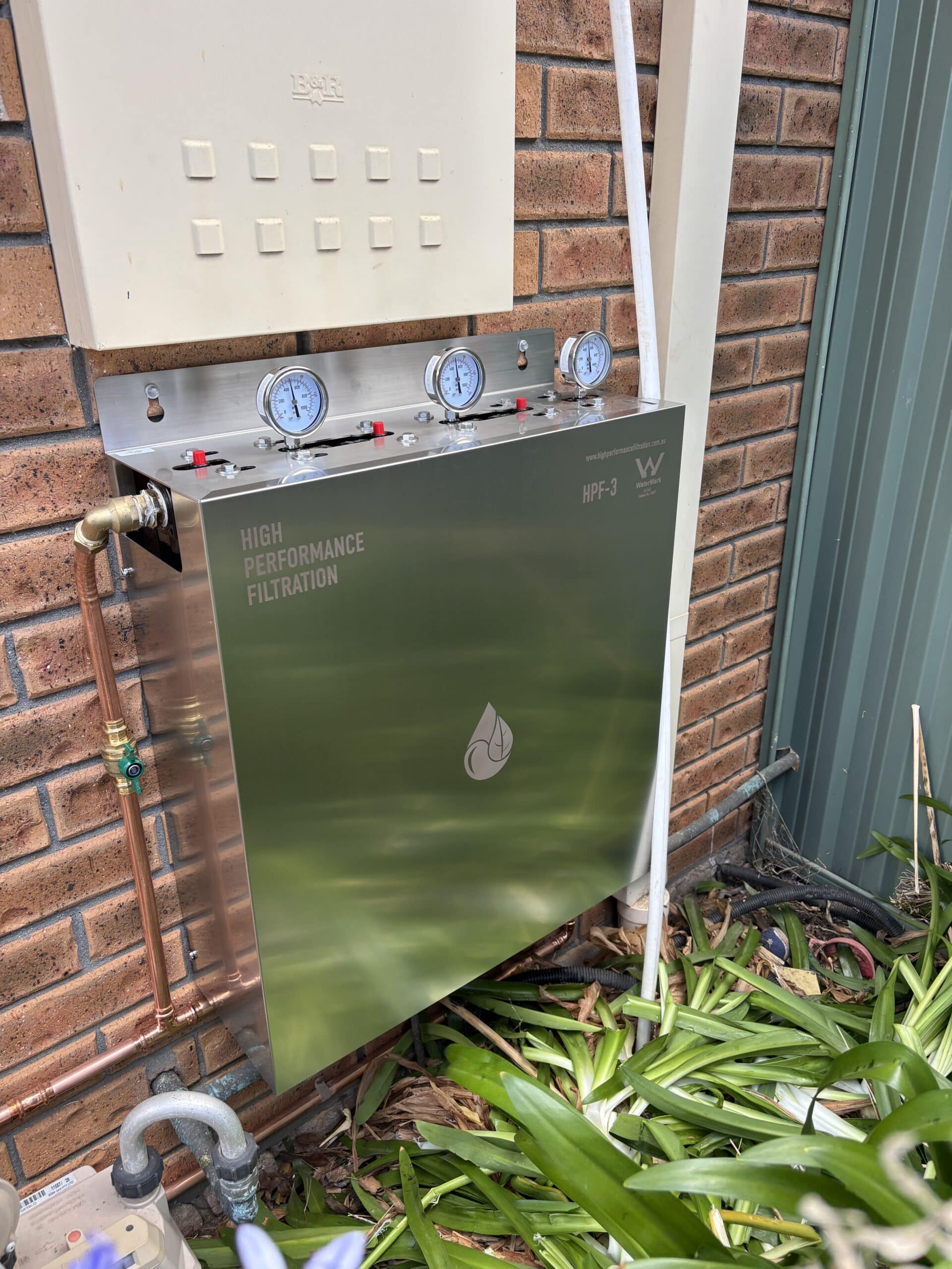 Wall-mount filtration cabinet on brick wall with gauges