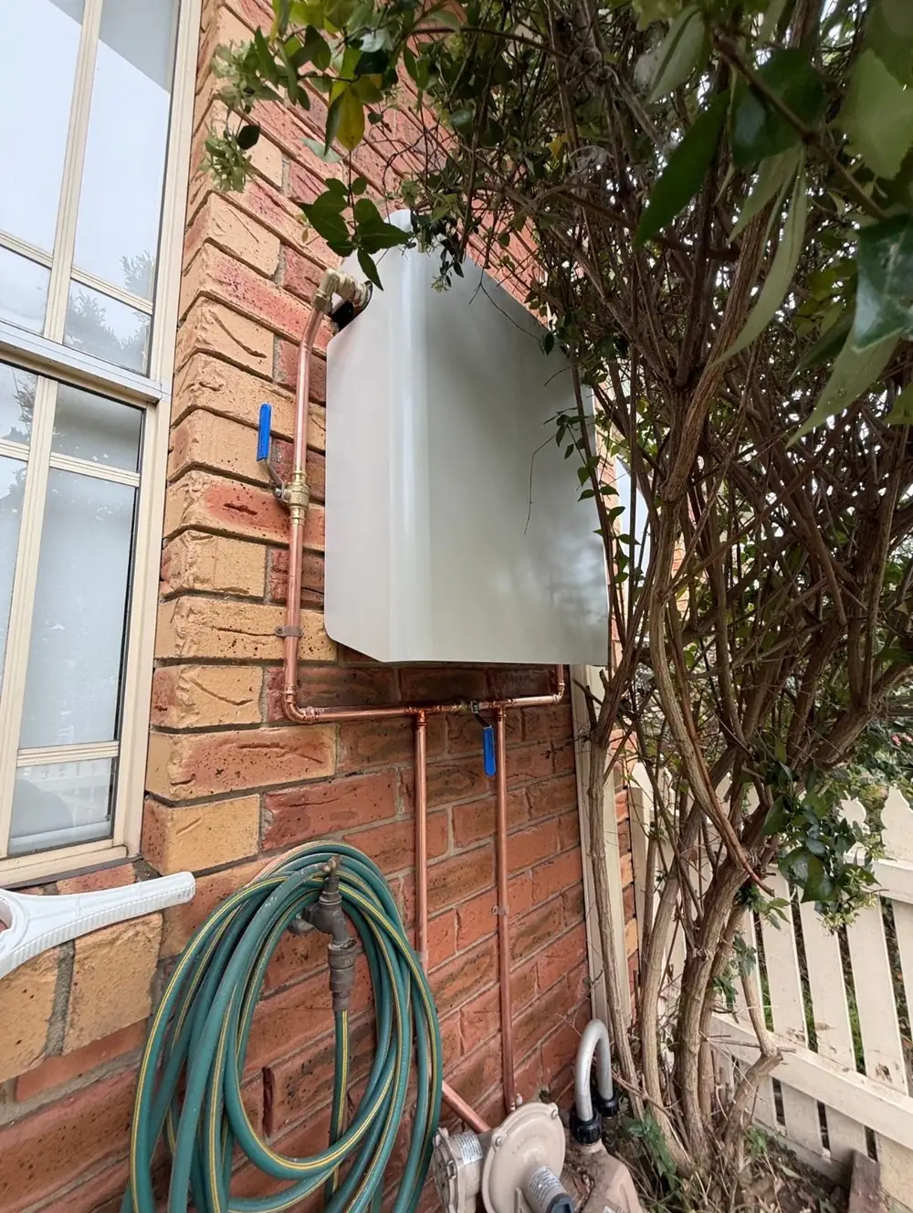 Whole House Filtration unit in Surfmist, wall mounted on brick